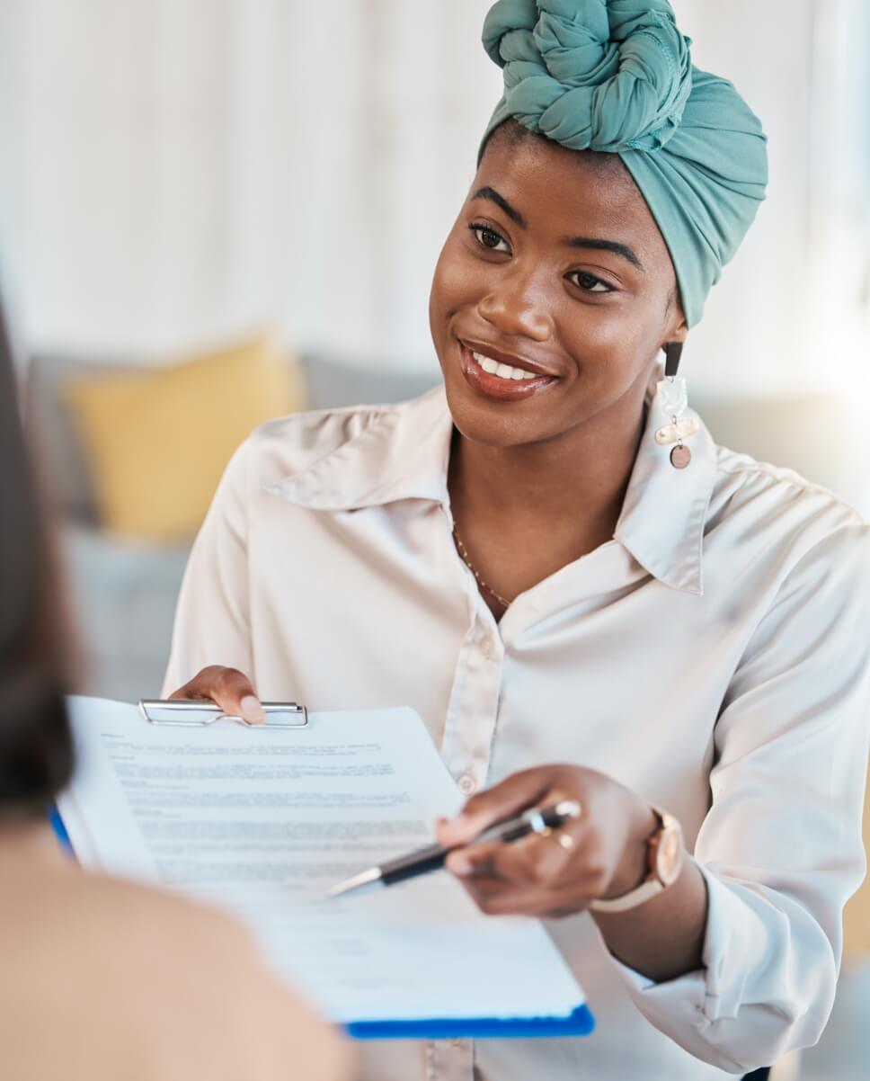 Woman smiling, holding clipboard and pen